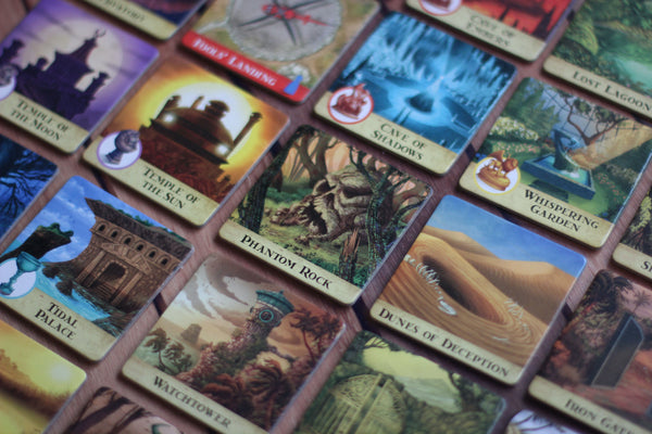 A photograph of several cards with fantasy illustrations of various locations, monsters, and lanscapes. Each has a border and a title, as though they are for a board or a card game of unknown title and intent