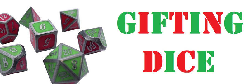 A photo of the Pandering Afterglow Dice set from D20collective, a metal dice set with green and pink sides, against a white background. Next to the dice are the worlds 'Gifting Dice' in stylized letters in alternating red and green colors