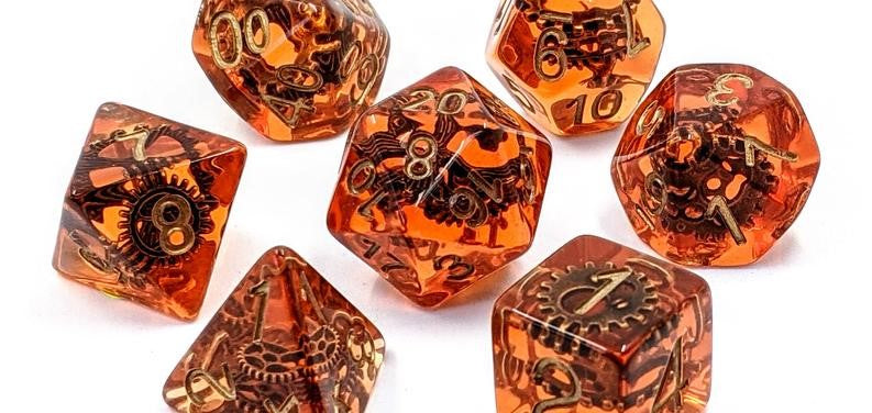 A photo of a set of orange dice, with gears inside the resin. 