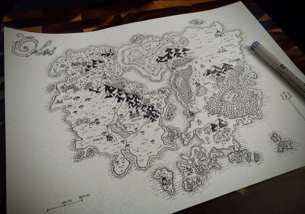 A photo of a hand-drawn black and white fantasy map against a wooden tablet