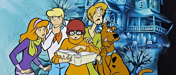 A portion of the Betrayal at Mystery Mansion box art, showing the scooby gang in front of a blue-tinted haunted mansion